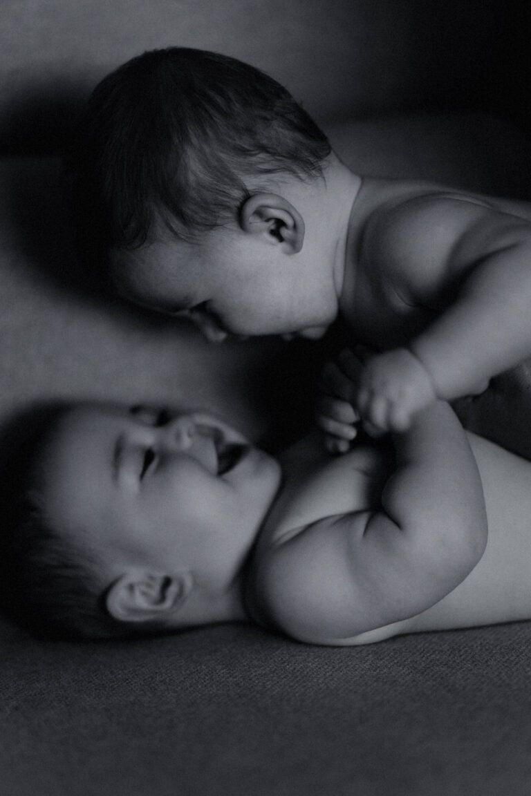 Madre y bebé tumbados cara a cara, en blanco y negro