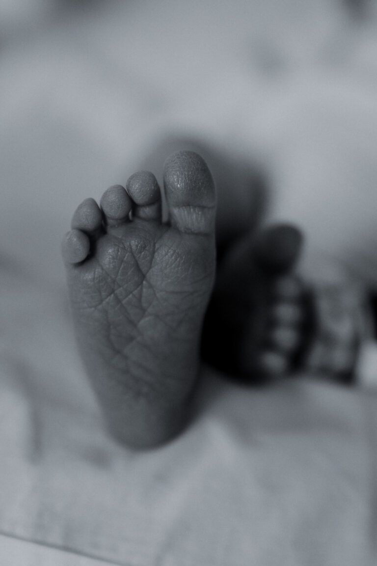 Pies de un bebé recién nacido en blanco y negro
