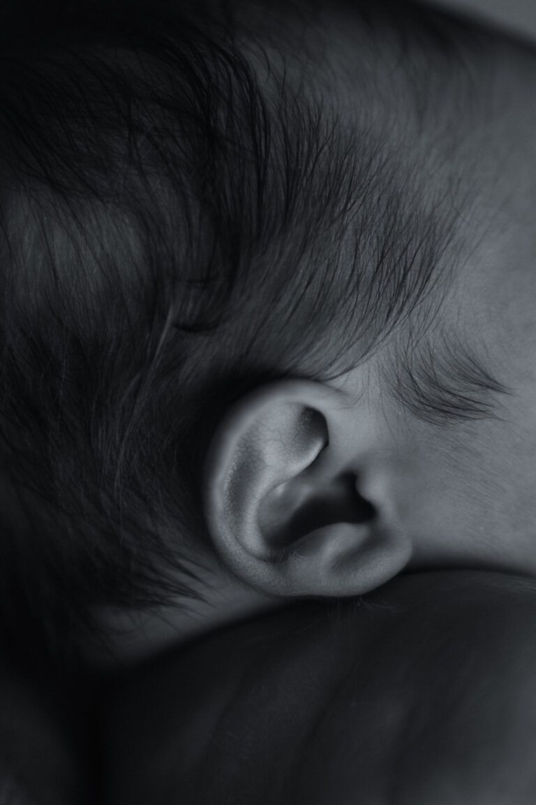 Oreja y cabecita de un recién nacido, en blanco y negro